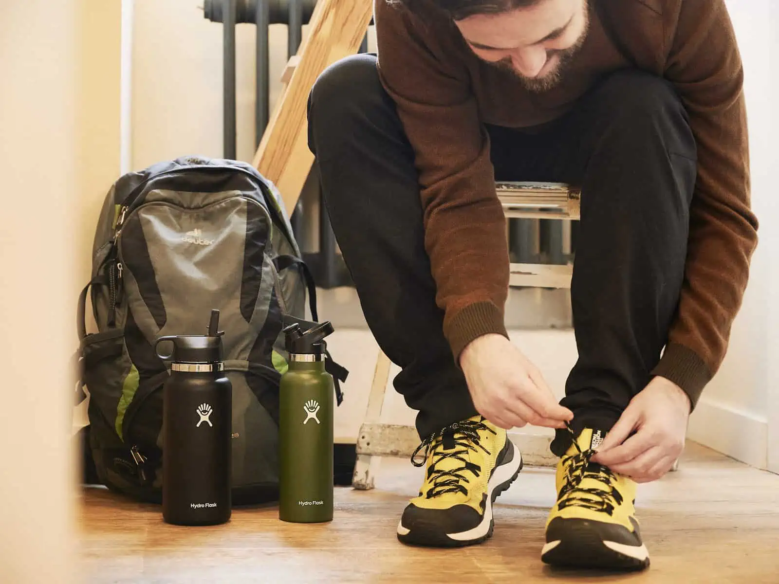 Image Descriptions: A landscape format image.&nbsp;&nbsp;Matt prepares for a walk.&nbsp;&nbsp;He is sat on a low seat indoors, leaning forward,&nbsp;&nbsp;tying the laces on his yellow running shoes.&nbsp;&nbsp;He is surrounded by white walls and t…