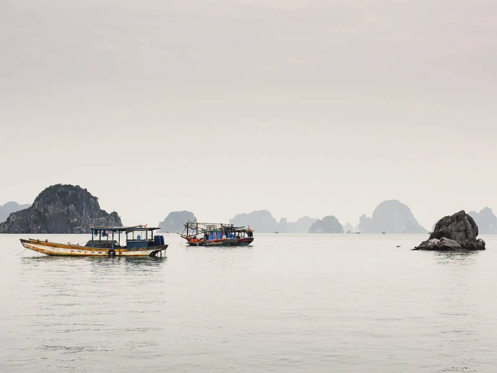 traditional vietnamese junk boats sailing near Bai Tu Long Bay Vietnam